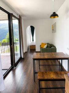a living room with a wooden table and a balcony at Container House Zakani in Zak'at'kari +16 photos