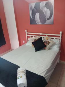 a bed with black and white pillows on it at Studio Royal Trianon Centro in Campos dos Goytacazes