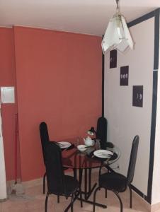 a dining room with a red wall and a table and chairs at Studio Royal Trianon Centro in Campos dos Goytacazes
