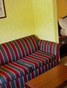 a striped couch in a room with a table at Magnolia Inn in Stockbridge