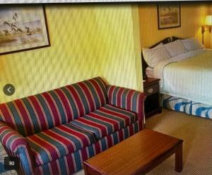 a hotel room with a couch and a bed at Magnolia Inn in Stockbridge