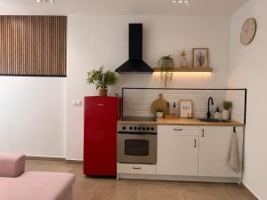 a kitchen with a red refrigerator and white cabinets at Andalucía Suites in Almería