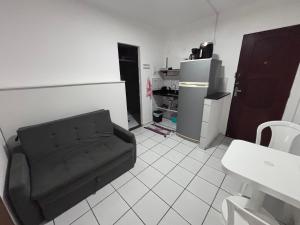 ein Wohnzimmer mit schwarzem Sofa und Kühlschrank in der Unterkunft Charme 239 in Natal