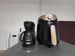 eine Kaffeemaschine, die auf einer Theke neben einer Mikrowelle steht in der Unterkunft Charme 239 in Natal