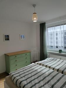 a bedroom with two beds and a dresser and a window at Apartman AK Slatinany in Chrudim