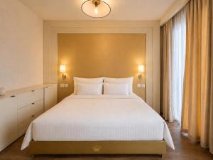 a bedroom with a large white bed in a room at Lusso Hotel in Prishtinë