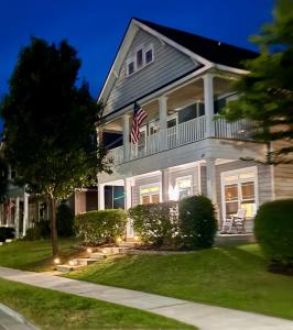 a large white house with an american flag at Fenced Yard, Pool, Lazy River SAV Area Oasis! in Savannah