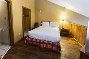 a bedroom with a bed and a table and a lamp at Timbers Lodge in Pigeon Forge