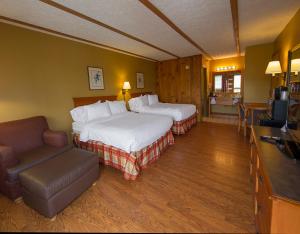 a hotel room with two beds and a couch at Timbers Lodge in Pigeon Forge +57 photos