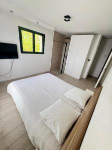 a bedroom with a large white bed and a television at villa sam in Feyzin +3 photos