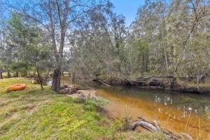a river with a red boat on the side of it at Davali at Mogo in Mogo