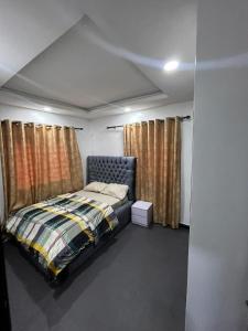 a bedroom with a bed in a room with curtains at ParamountLuxe 4 bedroom duplex in Ikeja in Ikeja
