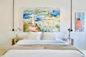 a bedroom with a bed with a painting on the wall at B&B Petit-Hallet in Hannut