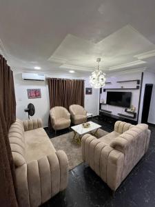a living room with two couches and a television at ParamountLuxe 4 bedroom duplex in Ikeja in Ikeja