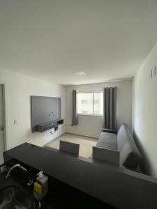 a living room with a couch and a flat screen tv at Studio Design 305 in Sobral