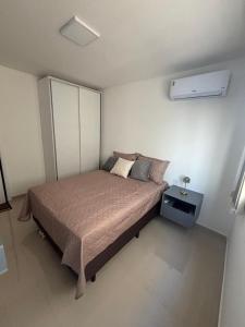 a bedroom with a bed with a night stand next to it at Studio Design 305 in Sobral
