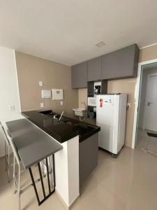 a kitchen with a white refrigerator and a counter top at Studio Design 305 in Sobral