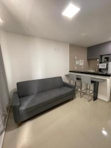 a living room with a couch and a kitchen at Studio Design 305 in Sobral +3 photos
