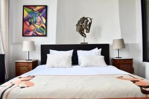 a bedroom with a large white bed with two lamps at B&B Petit-Hallet in Hannut