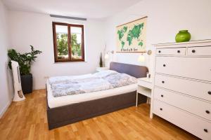 a bedroom with a bed and a dresser at FeWo Alte Mainbrücke in Würzburg