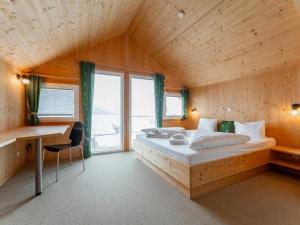 a bedroom with a large bed in a wooden room at The Laerch in Hohentauern