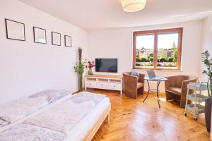 a bedroom with two beds and a tv and a table at FeWo Alte Mainbrücke in Würzburg