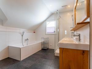 a bathroom with a tub and a sink and a bath tub at The Laerch in Hohentauern +42 photos