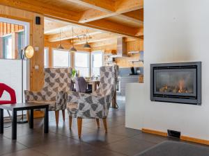 a living room with a fireplace and a table and chairs at The Laerch in Hohentauern