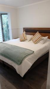 a large bed with two pillows on top of it at Departamento Pucon Parque in Pucón +8 photos