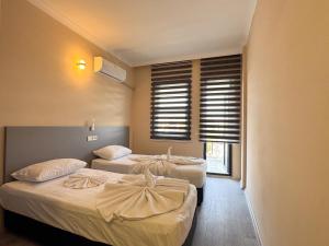 a hotel room with two beds and a window at Ayliz City Otel in Manavgat