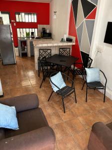 a living room with a table and chairs and a kitchen at Buganvilias Quepos No 1 con aire acondicionado in Quepos