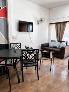 a living room with a table and chairs and a couch at Buganvilias Quepos No 1 con aire acondicionado in Quepos