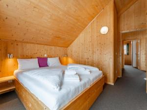 a bedroom with a bed in a wooden room at Tauern Lodge in Hohentauern