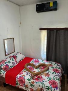 a bed with a heart shaped snake on it at Buganvilias Quepos No 1 con aire acondicionado in Quepos