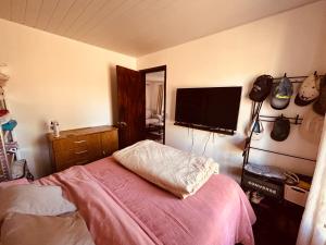 a bedroom with a bed and a flat screen tv at Tejanos in La Paloma