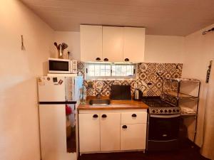 a small kitchen with a refrigerator and a microwave at Tejanos in La Paloma +2 photos