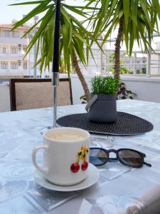 a cup of coffee sitting on a table with glasses at Ayliz City Otel in Manavgat