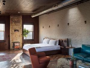 a bedroom with a bed and a brick wall at Wm. Mulherin's Sons Hotel in Philadelphia