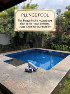 a swimming pool with a sign next to it at Casa Theo in Kelaniya