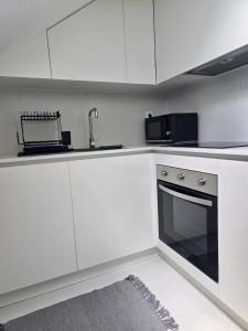 a kitchen with white cabinets and a sink and a stove at Domus Viriato in Viseu +19 photos