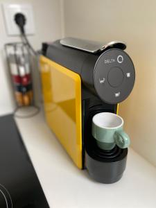 a coffee maker with a green coffee cup in it at Domus Viriato in Viseu