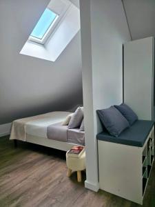 a small bedroom with a bed and a skylight at Domus Viriato in Viseu