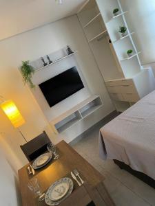 a living room with a table and a television at Casa 24 m2 aconchegante com AC in Sorocaba