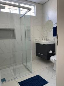 a bathroom with a glass shower and a toilet at Casa 24 m2 aconchegante com AC in Sorocaba