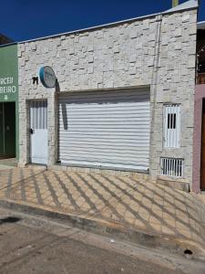 a garage with two doors on a brick building at Casa 24 m2 aconchegante com AC in Sorocaba