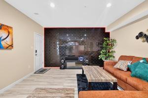 a living room with a couch and a brick wall at Sunshine Cozy Crib in Glenarden