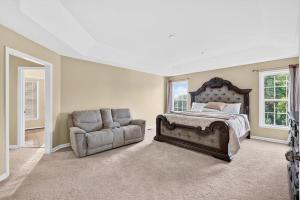 a bedroom with a bed and a couch and a chair at Sunshine Cozy Crib in Glenarden