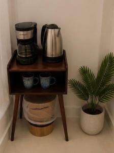 a small table with a coffee maker and a plant at Airhome free shuttle in Panama City