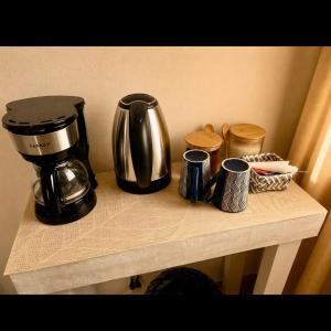 a counter with a coffee maker and cups on it at Airhome free shuttle in Panama City +4 photos
