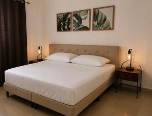 a bedroom with a large bed with two lamps on tables at Airhome free shuttle in Panama City